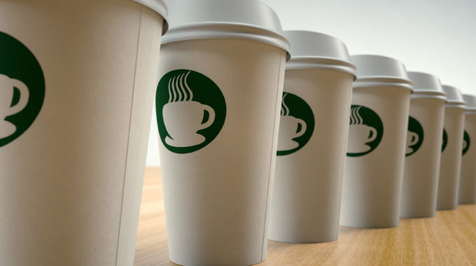 Paper Coffee Cups On Arranged In A Row With A Green Starbucks-like Logo
